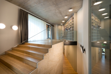 Dům, který se na dotek otvírá majitelům i přírodě - Interiérový minimalismus z nábytku na míru v barvě bílé kávy, šedých pohledových betonů a dubových podlah.